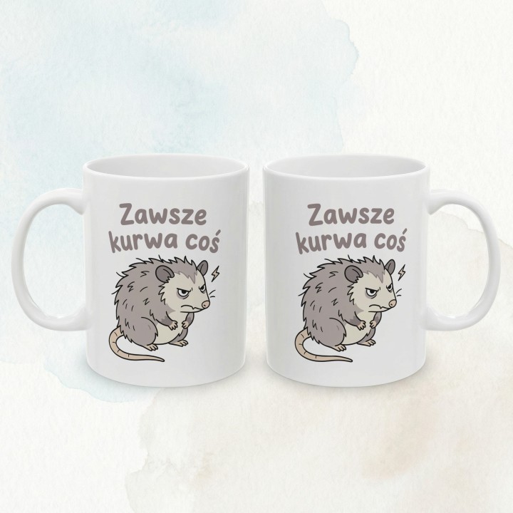 Biały kubek z szarym napisem i oposem wyglądającym na zirytowanego.