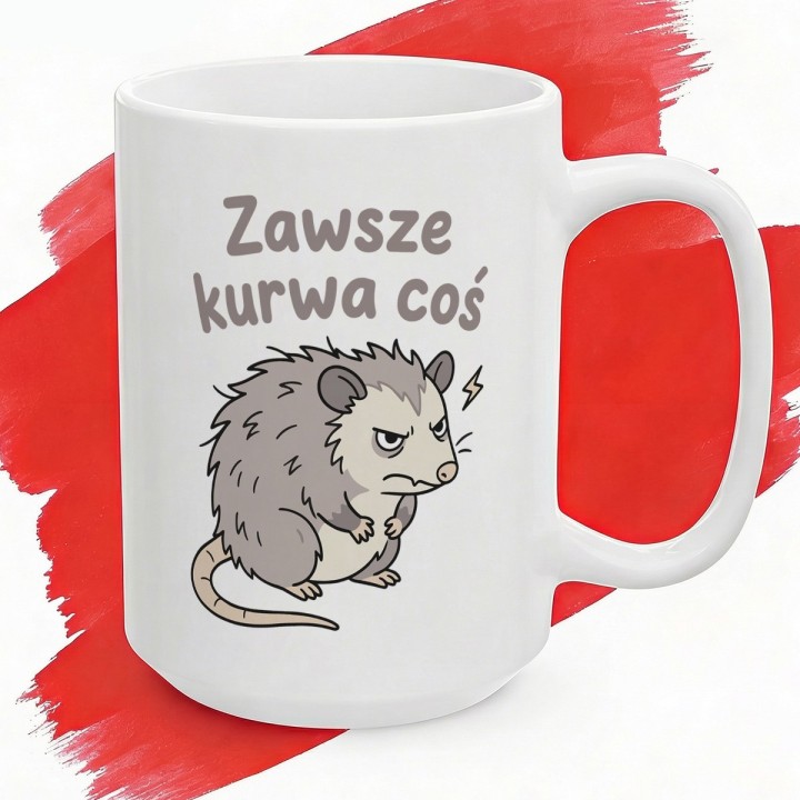 Biały kubek z napisem „Zawsze kurwa coś” i wkurzonym oposem.